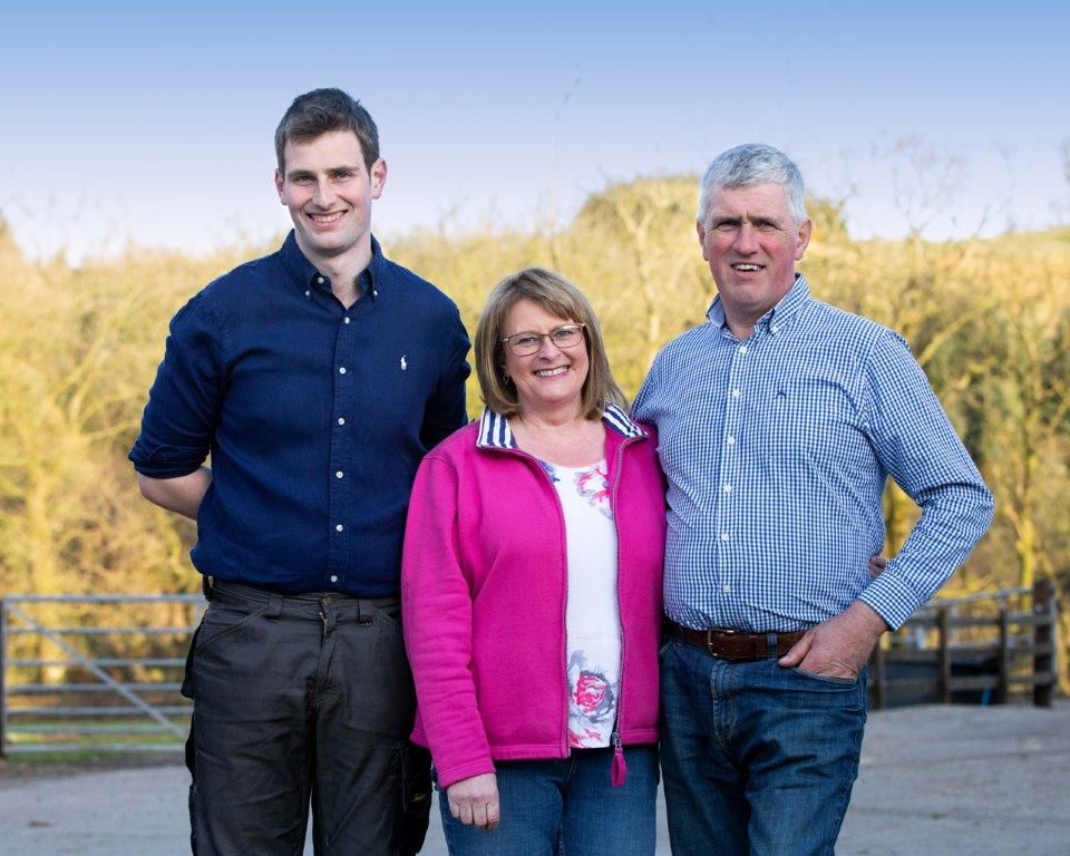 Campbell family stood in front of trees in the sun at Low Ballees Farm